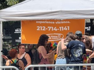 A crowd gathers and hugs in front of an orange AVP sign